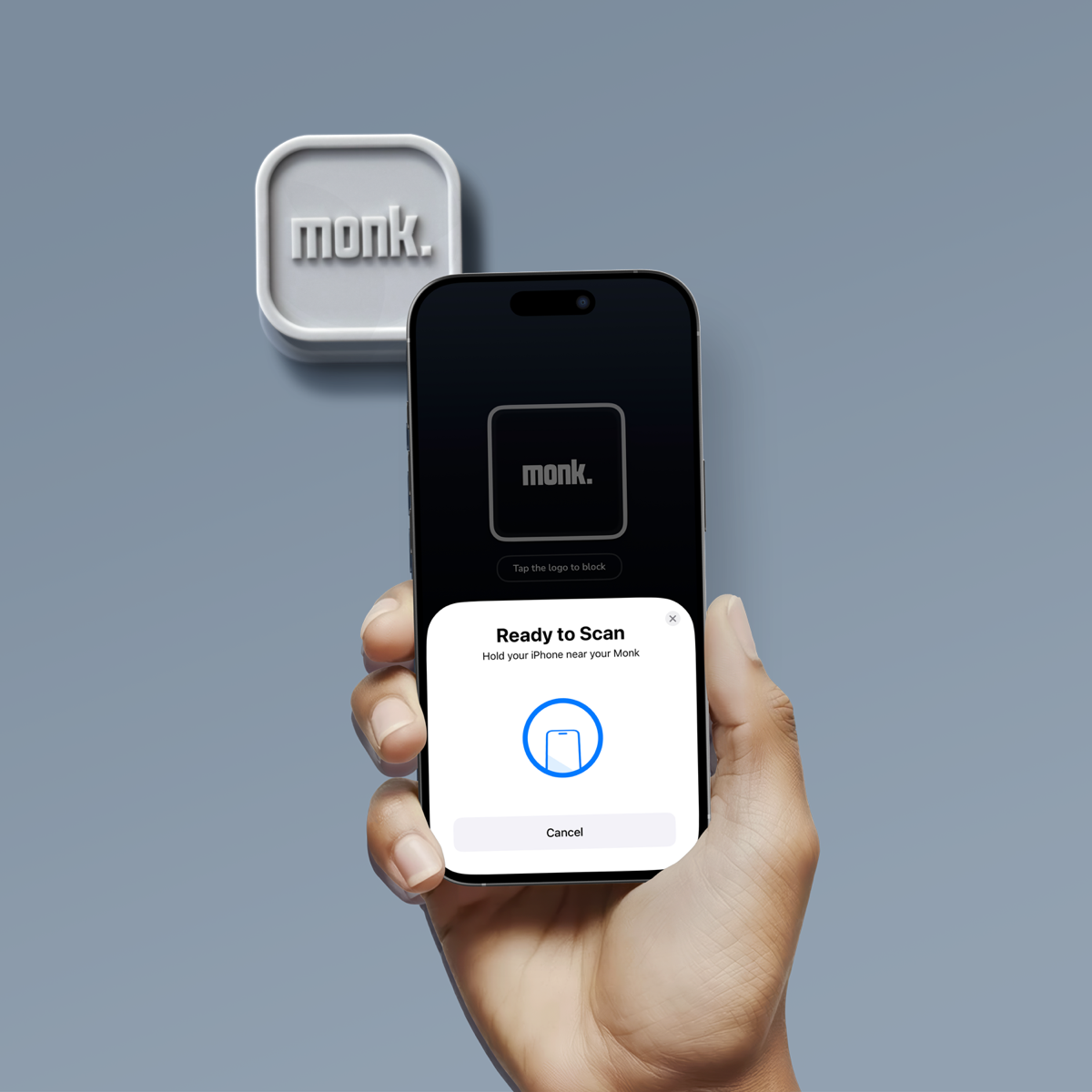 Una mano sostiene un iPhone escaneando el dispositivo Monk por NFC